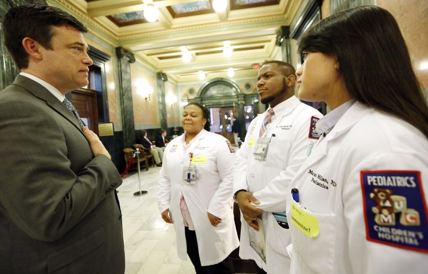 Dr. Mariel Milan, right, joins other pediatric residents from the University of Mississippi Medical Center as they confer with state Sen. Will Longwitz, R-Madison, about childhood vaccinations during a visit to the Capitol, Tuesday, Feb. 10, 2015, in Jackson, Miss. According to the Centers for Disease Control and Prevention, Mississippi has the highest measles immunization rate in the country for children entering kindergarten. (AP Photo/Rogelio V. Solis)