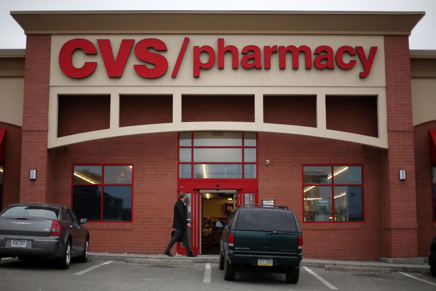 In this March 17, 2014 photo, a man walks in front of a CVS/Pharmacy in Dormont, Pa. CVS reports quarterly financial results on Tuesday, Feb. 10, 2015. (AP Photo/Gene J. Puskar)