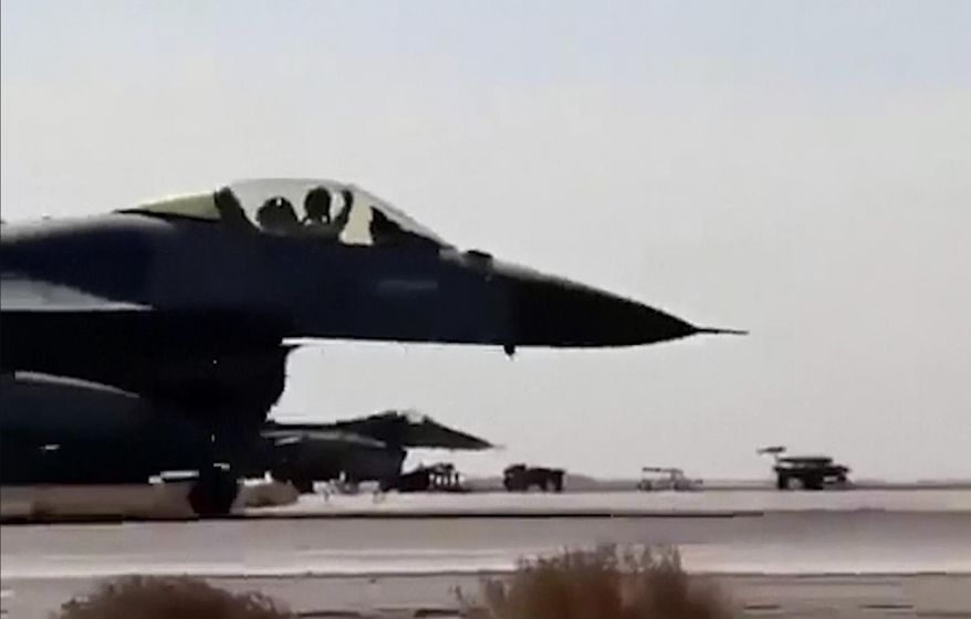 In this image made from Wednesday, Feb. 4, 2015, video provided by Jordanian military via Roya TV, an air force pilot raises his arm as he taxis his jet at Mowafak Al-Salti airbase in Azraq, Jordan. The military carried out airstrikes on Islamic State weapons depots and training sites on Thursday and Friday. King Abdullah II has thrust Jordan to the center of the war against the Islamic State group with his pledge of relentless retaliation for the killing of one of his pilots. (AP Photo/Jordanian military via Roya TV)