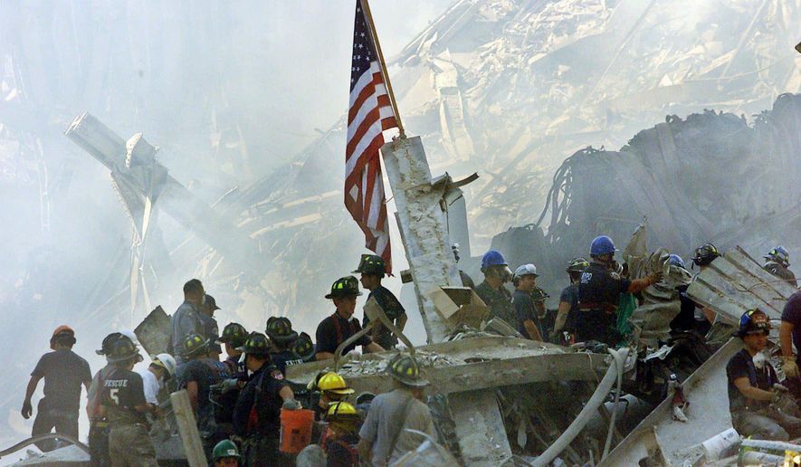 An American flag flies over the rubble of the collapsed World Trade Center buildings in New York on Sept. 13, 2001. (Associated Press) **FILE**