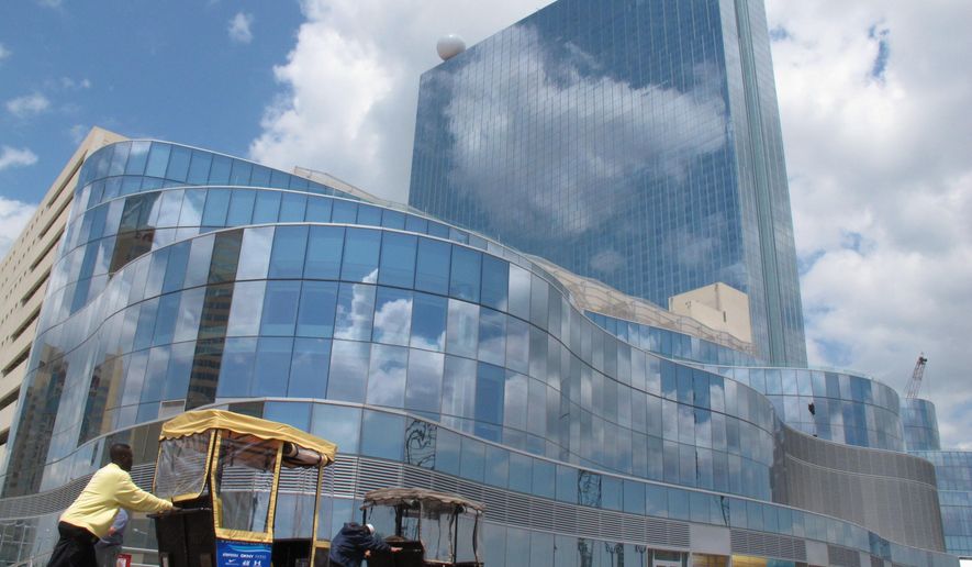 In this May 10, 2012 photo, a rolling chair operator works in front of the Revel Casino Hotel on the Atlahntic City, N.J. Boardwalk. On Tuesday Feb. 10, 2015, the owners of the casino, which shut down on Sept. 2, 2014, canceled a deal to sell it to a Florida developer for $95.4 million,a day after the deadline for the sale had passed. (AP Photo/Wayne Parry)