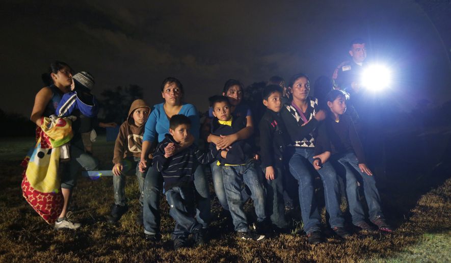 A group of immigrants from Honduras and El Salvador cross the U.S.-Mexico border illegally in Granjeno, Texas, June 25, 2014. (AP Photo/Eric Gay, File) ** FILE **