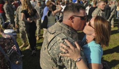Staff Sergeant Steven Smith of the 1st Brigade Combat Team, 3d Infantry Division, is welcomed home by his wife Jackie at Fort Stewart in Georgia after a deployment. (Associated Press) ** FILE **