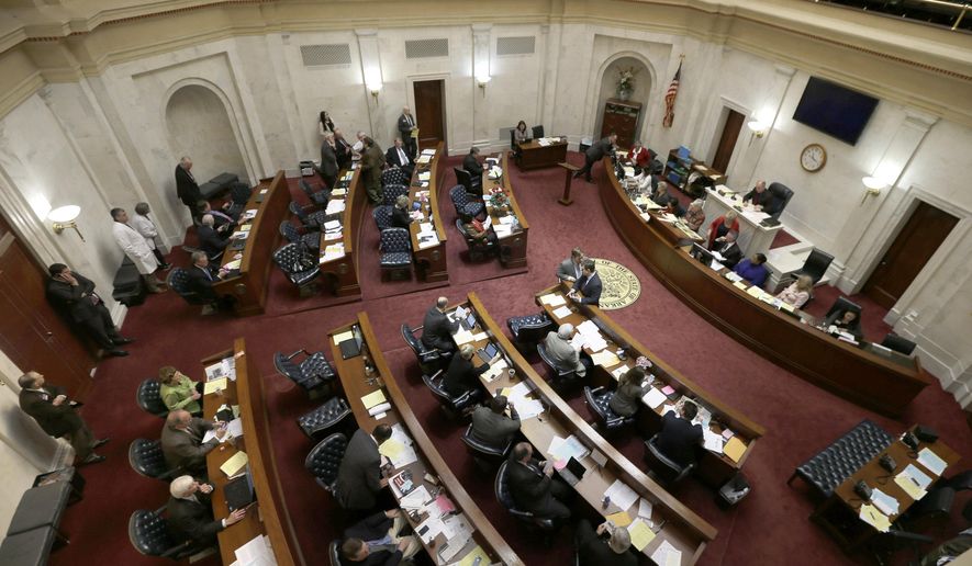 Legislator gather in the Senate chamber at the Arkansas state Capitol in Little Rock, Ark., Thursday, Feb. 12, 2015. The Senate passed a bill that bans using telemedicine to administer the abortion pill Thursday. The Senate Public Health, Welfare and Labor Committee on Wednesday endorsed the House-backed measure which would require a doctor to be present when abortion-inducing medicine is taken. Anti-abortion rights groups have called the proposal their top priority during the legislative session, and Republican Gov. Asa Hutchinson has said he supports the ban. (AP Photo/Danny Johnston)