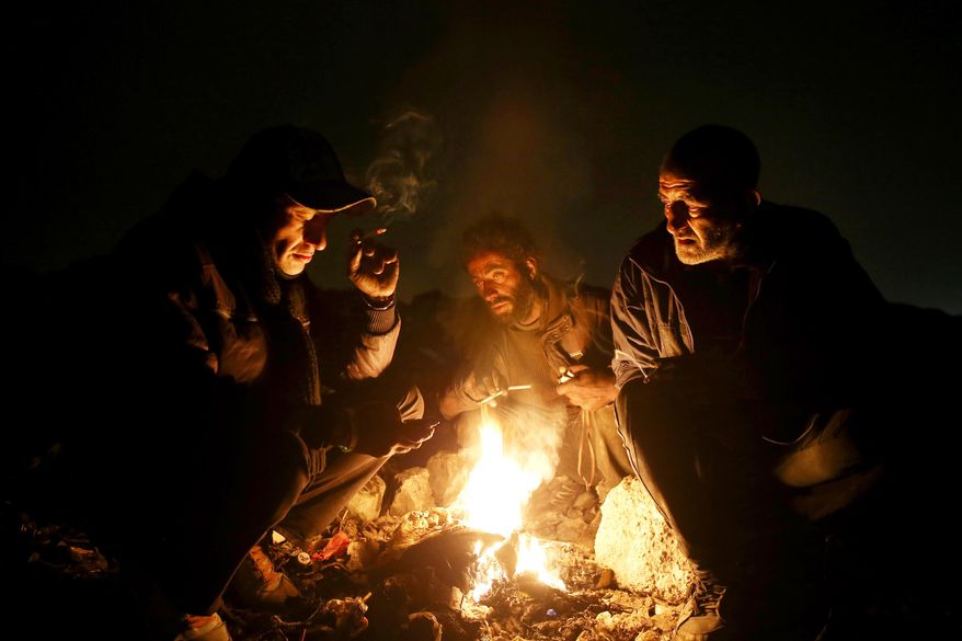 In this Wednesday, Feb. 11, 2015 photo, drug addicts gather around fire to warm themselves, in a suburb of Tehran, Iran. Anti-narcotics and medical officials say more than 2.2 million of Iran's 80 million citizens already are addicted to illegal drugs, including 1.3 million on registered treatment programs. They say the numbers keep rising annually, even though use of the death penalty against convicted smugglers has increased, too, and now accounts for more than nine of every 10 executions. (AP Photo/Ebrahim Noroozi)