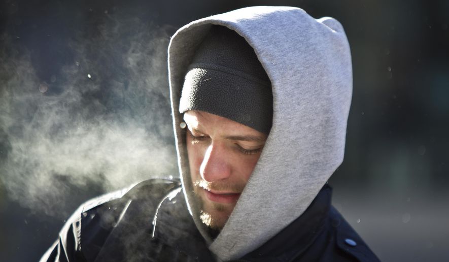 Dino Kahrimanovic collects coins from parking meters in downtown Grand Rapids, Mich., Thursday, Feb. 12, 2015. Wind chill readings could reportedly plunge to 35 below, causing serious dangers to humans and animals. "I'm in this everyday," said Kahrimanovic, who works for the city. "You learn to deal with it." (AP Photo/The Grand Rapids Press, Cory Morse) ALL LOCAL TELEVISION OUT; LOCAL TELEVISION INTERNET OUT MBI