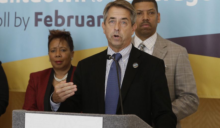 In this photo taken Feb. 9, 2015, Peter Lee, center, executive director of Covered California, the state's health insurance marketplace, discusses health insurance sign ups at a news conference with Sacramento Mayor Kevin Johnson, right, in Sacramento Calif. With the open enrollment deadline Sunday, California officials said Thursday, Feb. 12, 2015, that the state is falling short of its goal to sign up 1.7 million people for private health coverage in the second year of the federal health expansion. (AP Photo/Rich Pedroncelli)