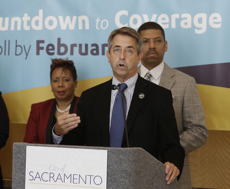 In this photo taken Feb. 9, 2015, Peter Lee, center, executive director of Covered California, the state's health insurance marketplace, discusses health insurance sign ups at a news conference with Sacramento Mayor Kevin Johnson, right, in Sacramento Calif. With the open enrollment deadline Sunday, California officials said Thursday, Feb. 12, 2015, that the state is falling short of its goal to sign up 1.7 million people for private health coverage in the second year of the federal health expansion. (AP Photo/Rich Pedroncelli)