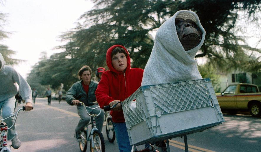 FILE - This image released by Universal Pictures shows Henry Thomas as Elliott and E.T. in a basket on a bicycle in a scene from director Steven Spielberg's 1982 movie "E.T.: The Extra-Terrestrial." As astronomers debate whether it would be a good idea to send signals into the universe to look for extra-terrestrial life, in science-fiction movies, aliens sometimes come in peace — and often do not. (AP Photo/Universal Pictures)