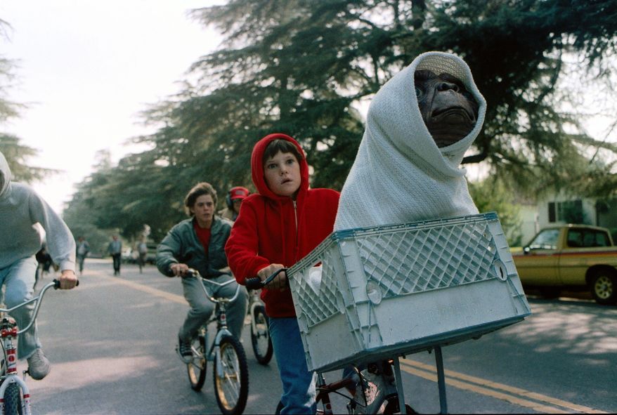 FILE - This image released by Universal Pictures shows Henry Thomas as Elliott and E.T. in a basket on a bicycle in a scene from director Steven Spielberg's 1982 movie "E.T.: The Extra-Terrestrial." As astronomers debate whether it would be a good idea to send signals into the universe to look for extra-terrestrial life, in science-fiction movies, aliens sometimes come in peace — and often do not. (AP Photo/Universal Pictures)