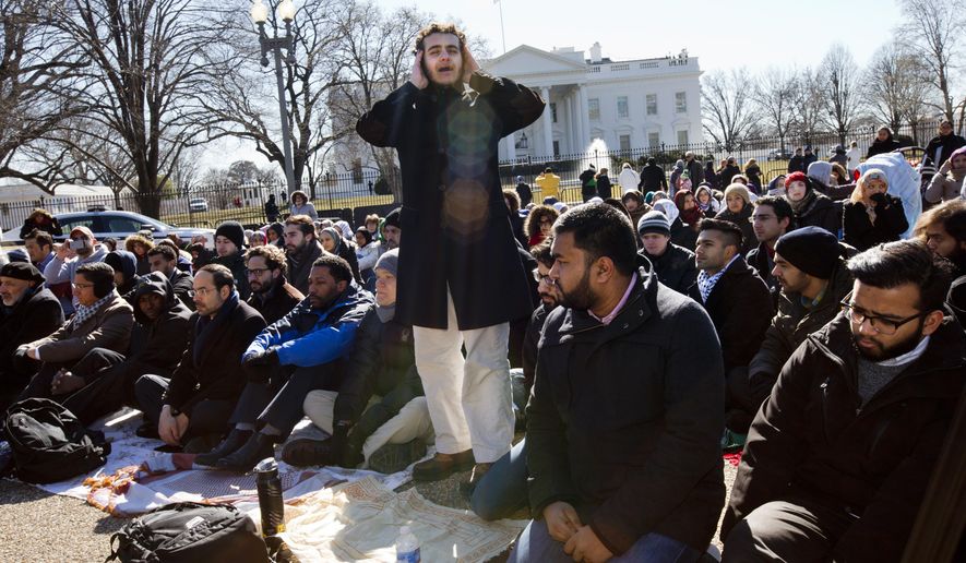A student from Georgetown University, who asked not to be named, sings the call to prayer as a group of Muslim people and their supporters prepare to say the Friday prayers outside the White House in Washington, Friday, Feb. 13, 2015, in the wake of the murder of three young North Carolina Muslims. The gathering was in memory of the Chapel Hill shooting victims, and to press federal authorities for a hate crime investigation.? (AP Photo/Jacquelyn Martin)