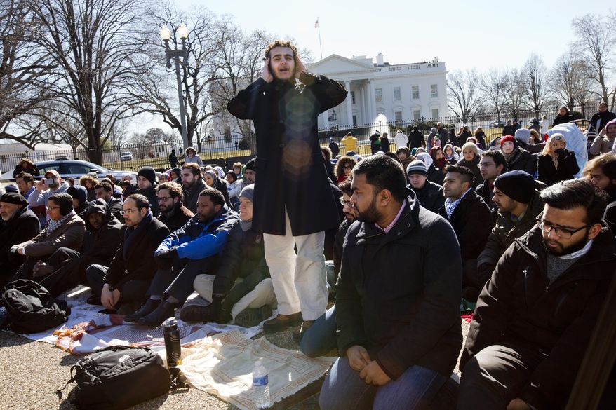 A student from Georgetown University, who asked not to be named, sings the call to prayer as a group of Muslim people and their supporters prepare to say the Friday prayers outside the White House in Washington, Friday, Feb. 13, 2015, in the wake of the murder of three young North Carolina Muslims. The gathering was in memory of the Chapel Hill shooting victims, and to press federal authorities for a hate crime investigation.? (AP Photo/Jacquelyn Martin)