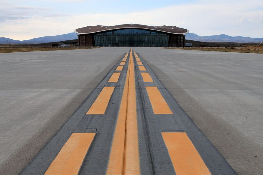 FILE-This Dec. 9, 2014, file photo shows the taxiway leading to the hangar at Spaceport America in Upham, N.M. Sen. George Munoz has proposed legislation that calls for selling the futuristic hangar, the nearly two-mile-long runway and the 18,000 acres that come with it. (AP Photo/Susan Montoya Bryan)