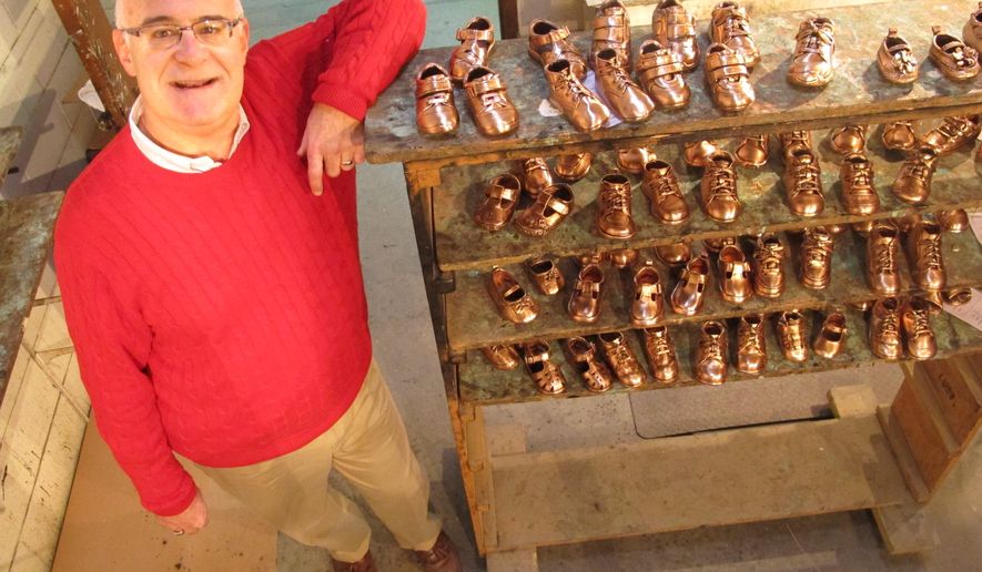 Tuesday, Feb. 10, 2015 photo, Robert Kaynes, CEO of American Bronzing Co., shows off some of the approximately 100 pairs of baby shoes his company bronzes each day, in Columbus, Ohio. Kaynes, the grandson of the company's founder, says the company bronzed 2,000 shoes a day in the 1970s but is experiencing a resurgence thanks to social media marketing. (AP Photo/Andrew Welsh-Huggins)