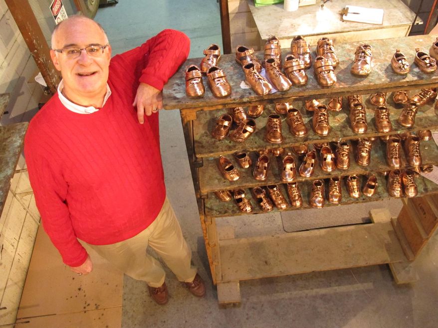 Tuesday, Feb. 10, 2015 photo, Robert Kaynes, CEO of American Bronzing Co., shows off some of the approximately 100 pairs of baby shoes his company bronzes each day, in Columbus, Ohio. Kaynes, the grandson of the company's founder, says the company bronzed 2,000 shoes a day in the 1970s but is experiencing a resurgence thanks to social media marketing. (AP Photo/Andrew Welsh-Huggins)