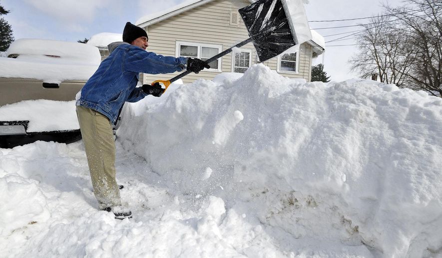 Allen Millette adds to the growing pile of snow in his yard in New Bedford, Mass., Sunday, Feb. 15, 2015. The National Weather Service is reporting snowfall over a foot across eastern Massachusetts, with pockets near 2 feet. (AP Photo/Standard Times, David W. Oliveira)