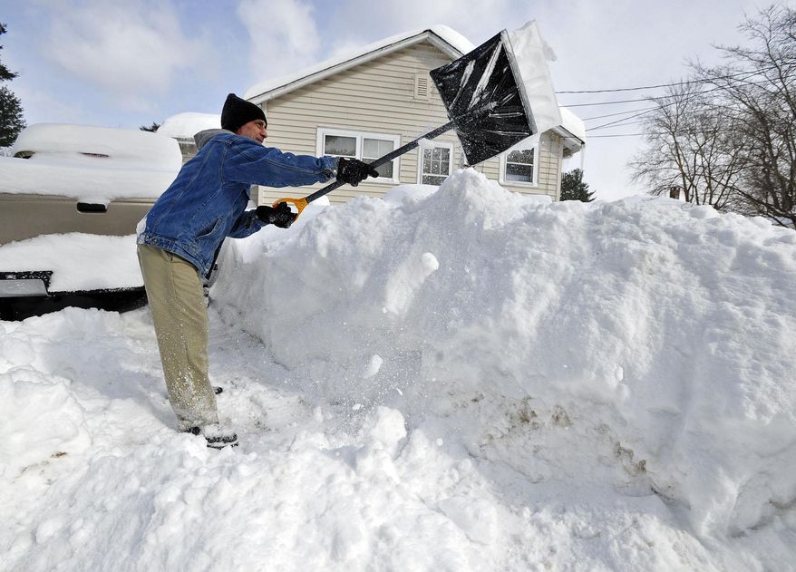 Allen Millette adds to the growing pile of snow in his yard in New Bedford, Mass., Sunday, Feb. 15, 2015. The National Weather Service is reporting snowfall over a foot across eastern Massachusetts, with pockets near 2 feet. (AP Photo/Standard Times, David W. Oliveira)