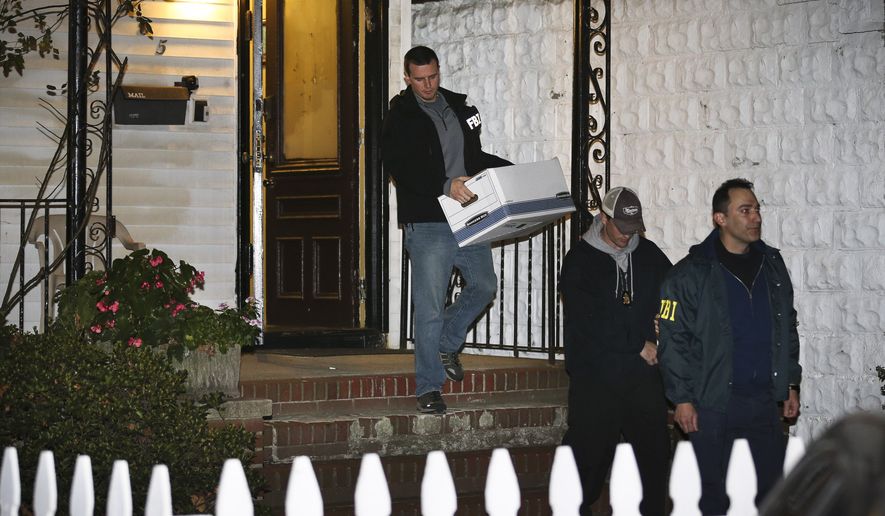 FBI agents remove evidence from the Brooklyn residence of Rabbi Mendel Epstein during an investigation, in New York, in this Oct. 10, 2013, file photo. Several defendants, including Epstein and another rabbi, are accused by the FBI of plotting to kidnap and beat a man to force him to grant a religious divorce. Epstein's trial starts Tuesday, Feb. 17, 2015, in federal court in New Jersey. Several co-defendants have pleaded guilty and others will join him in court this week. (AP Photo/John Minchillo, File)