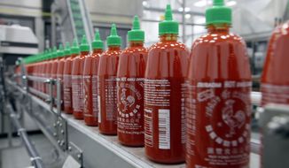 FILE - In the Tuesday, Oct. 29, 2013, file photo, Sriracha chili sauce is produced at the Huy Fong Foods factory in Irwindale, Calif. The Irwindale City Council voted Wednesday May 28, 2014 night to drop a public nuisance declaration and lawsuit against Huy Fong Foods, makers of Sriracha hot sauce. (AP Photo/Nick Ut, File)