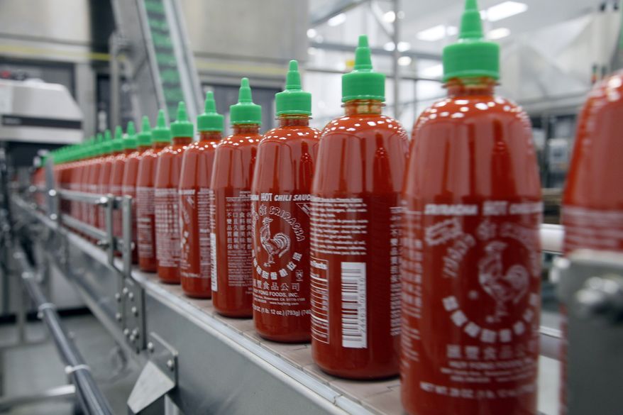 FILE - In the Tuesday, Oct. 29, 2013, file photo, Sriracha chili sauce is produced at the Huy Fong Foods factory in Irwindale, Calif. The Irwindale City Council voted Wednesday May 28, 2014 night to drop a public nuisance declaration and lawsuit against Huy Fong Foods, makers of Sriracha hot sauce. (AP Photo/Nick Ut, File)