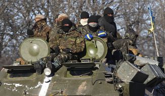 Ukrainian government soldiers sat on their armored vehicle driving on a road away from the town of Artemivsk as separatists pushed deeper into Debaltseve.