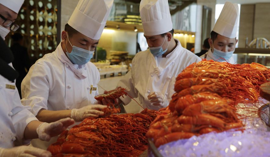 In this Feb. 9, 2015, photo, Chinese chefs prepare Boston lobsters at the Auspicious Garden restaurant in Pangu Seven Star Hotel in Beijing. Every morning the restaurant in Beijing receives 800 lobsters that have just crossed the Pacific aboard a cargo plane. In the evening, hundreds of diners fill the two-story restaurant in the gigantic hotel for a nearly $80 all-you-can-eat buffet with the New England specialty as the main attraction. (AP Photo/Andy Wong)