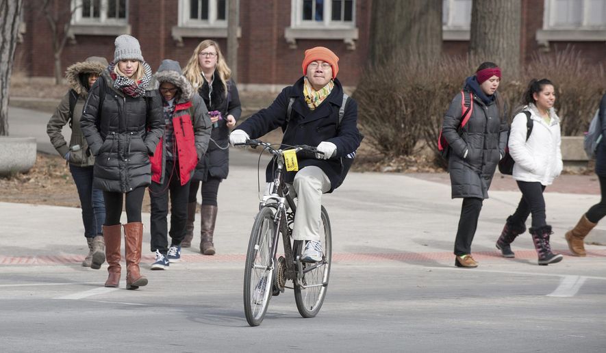 In this Feb. 16, 2015 photo University of Illinois students cross Fourth Street on campus in Champaign, Ill. Monday Feb. 16, 2015. A school spokeswoman says the University of Illinois at Urbana-Champaign has increased the number of in-state residents being accepted for fall 2015. (AP Photo/The News-Gazette, Rick Danzl) **FILE**