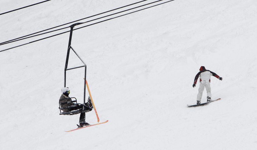 A skier relaxes on a chair lift as he climbs the mountain at the Sierra at Tahoe Ski Resort. (AP Photo)