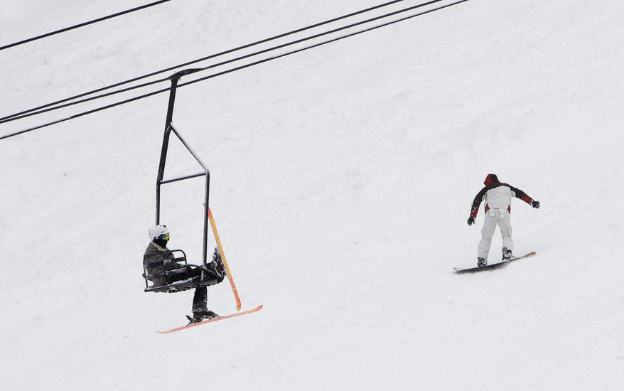 A skier relaxes on a chair lift as he climbs the mountain at the Sierra at Tahoe Ski Resort. (AP Photo)