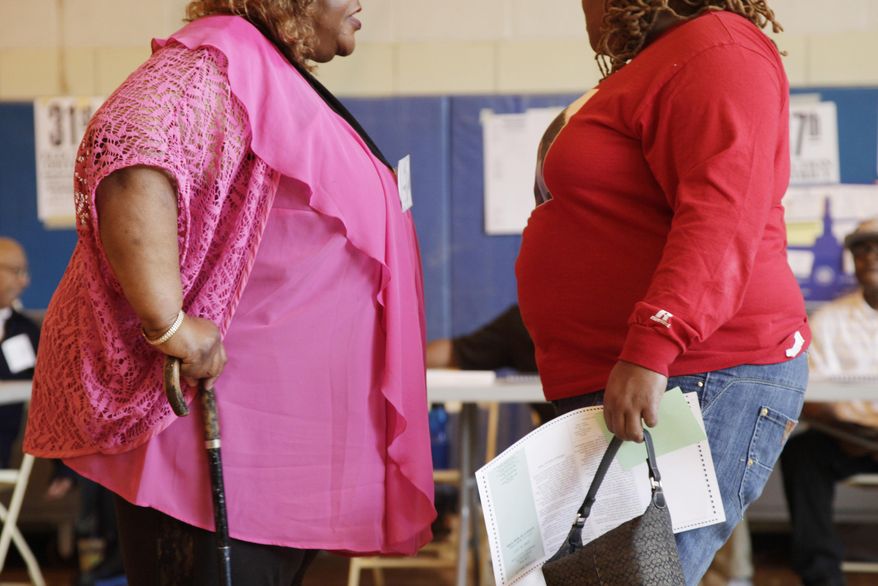 FILE - In this Tuesday, June 26, 2012 file photo, two overweight women speak to each other in New York. There may be more fruit, vegetables and healthy options available than ever before, but the world is mostly hungry for junk food, according to a study of eating habits in nearly 190 countries that was released on Wednesday, Feb. 18, 2015. (AP Photo/Mark Lennihan, File)