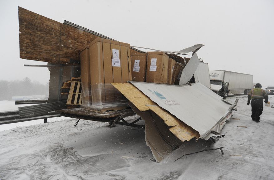 Crews from Hasse's Towing and Crane Service work the scene of a multi-vehicle accident in the eastbound lanes of I-94 near Exit 29 in Benton Township, Mich., Wednesday, Feb.18, 2015. Crews responded to numerous accidents as lake-effect snow made driving hazardous.(AP Photo/The Herald-Palladium, Don Campbell)