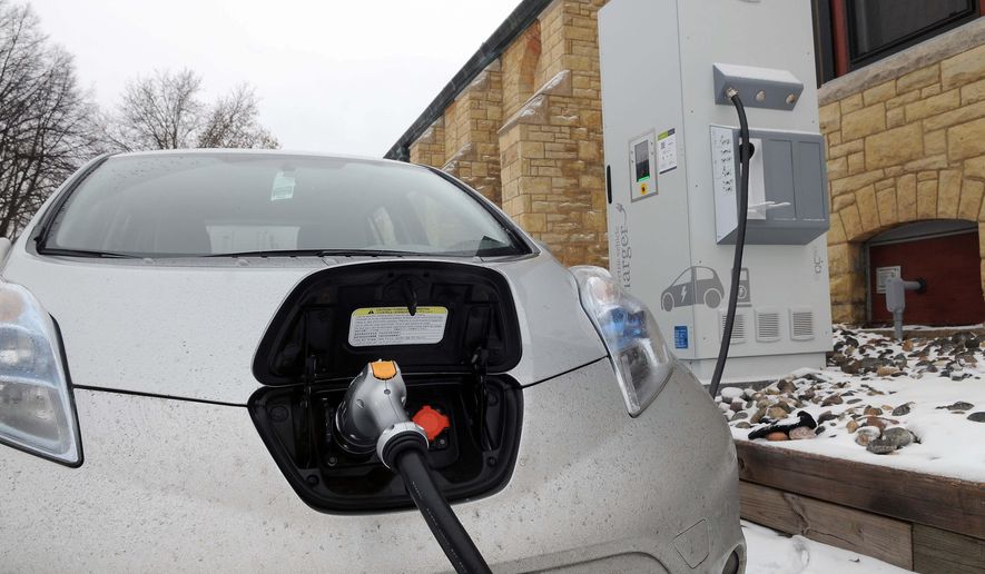 ADVANCED FOR RELEASE MONDAY, FEBRUARY 23, 2015 Dale Howey's Nissan Leaf electric car charges quickly using the fast charger in the parking lot of the Unitarian Universalist Church in St. Paul, on Tuesday, Feb. 10, 2015. (AP Photo/St. Paul Pioneer Press, Scott Takushi)