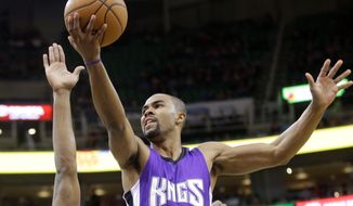 Sacramento Kings guard Ramon Sessions (9) lays the ball as Utah Jazz&#39;s Derrick Favors (15) defends and Dante Exum (11) looks on in the first quarter during an NBA basketball game Saturday, Feb. 7, 2015, in Salt Lake City. (AP Photo/Rick Bowmer)