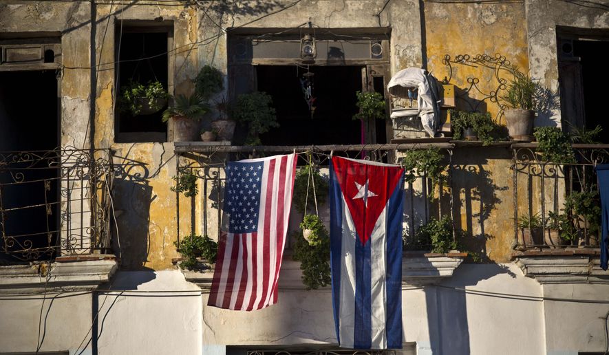 FILE - In this Dec. 19, 2014 file photo, a U.S. and Cuban flag hang from a balcony in Old Havana, Cuba. As the two countries to end a half-century of acrimony, President Barack Obama has made clear that he is moving quickly to take Cuba off the list of state sponsors of terror, saying in a televised address on his new Cuba policy in late 2014 that "at a time when we are focused on threats from al Qaeda to ISIL, a nation that meets our conditions and renounces the use of terrorism should not face this sanction." (AP Photo/Ramon Espinosa, File)