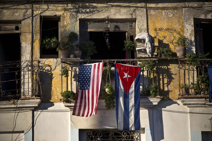 FILE - In this Dec. 19, 2014 file photo, a U.S. and Cuban flag hang from a balcony in Old Havana, Cuba. As the two countries to end a half-century of acrimony, President Barack Obama has made clear that he is moving quickly to take Cuba off the list of state sponsors of terror, saying in a televised address on his new Cuba policy in late 2014 that "at a time when we are focused on threats from al Qaeda to ISIL, a nation that meets our conditions and renounces the use of terrorism should not face this sanction." (AP Photo/Ramon Espinosa, File)