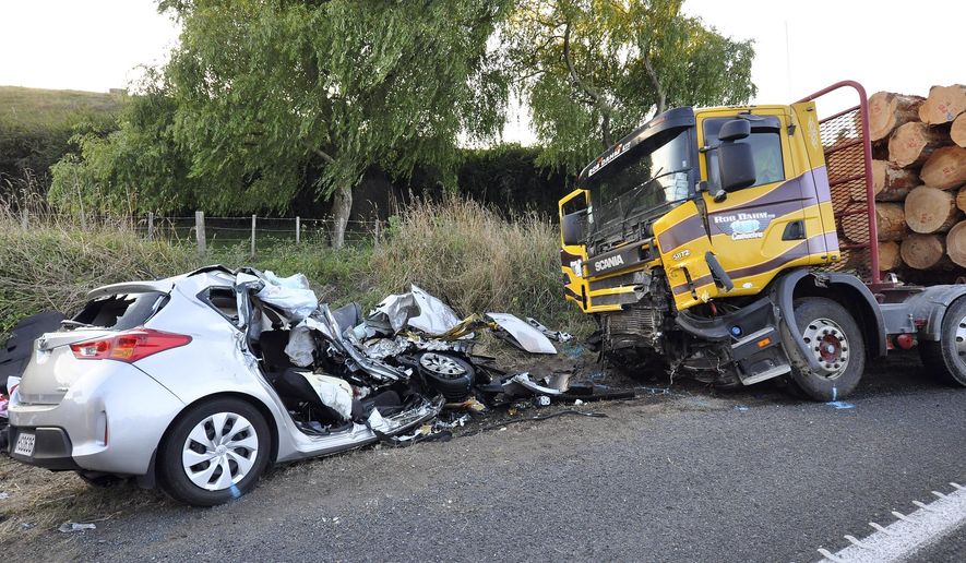 In this Tuesday Feb. 17, 2015 photo, a car and a logging truck sit damaged after they collided head-on near Tokoroa, New Zealand. New Zealand authorities said Thursday, Feb. 19 that U.S. citizens Warren Lee, his wife Aesoon Lee and the couple's daughter, Julia Lee were killed and their son critically injured when their car crashed into the logging truck. (AP Photo/NZ Herald, John van de Ven) AUSTRALIA OUT, NEW ZEALAND OUT
