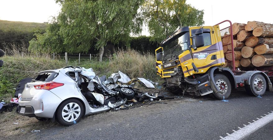 In this Tuesday Feb. 17, 2015 photo, a car and a logging truck sit damaged after they collided head-on near Tokoroa, New Zealand. New Zealand authorities said Thursday, Feb. 19 that U.S. citizens Warren Lee, his wife Aesoon Lee and the couple's daughter, Julia Lee were killed and their son critically injured when their car crashed into the logging truck. (AP Photo/NZ Herald, John van de Ven) AUSTRALIA OUT, NEW ZEALAND OUT