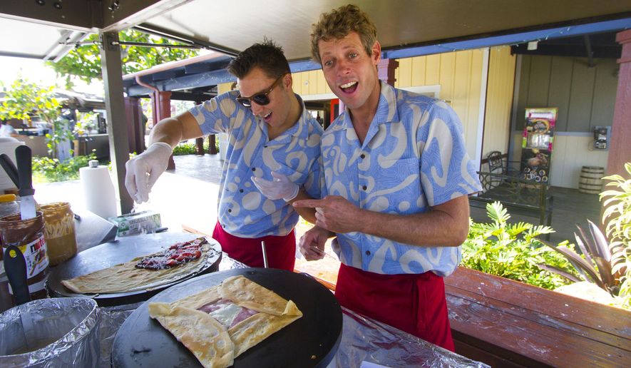 ** ADVANCE FOR SATURDAY FEB. 21 AND THEREAFTER ** In this photo taken Feb. 18, 2015, Bryce Campbell, left, and Jonathan Pajot, right, cook crepes inside their “Delice Crepes" food booth during the unveiling of the new Hukilau Marketplace at the Polynesian Cultural Center in Laie, Hawaii. The Polynesian Cultural Center always has been predominantly an all-day attraction with its re-created island villages, buffet and luau offerings, and elaborate evening show. But in the most ambitious expansion project since the center opened in Laie in 1963, the PCC has a new 119,000-square foot Hukilau Marketplace, which will feature more than 40 stores, eateries and attractions. (AP Photo/Honolulu Star-Advertiser, Dennis Oda)