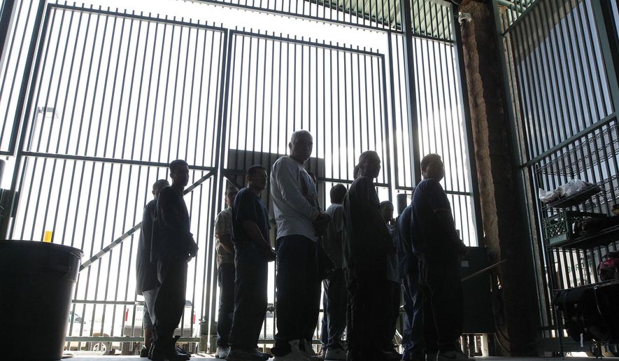 In this file photo from Thursday Aug. 9, 2012, persons are detained for being in the country illegally and are transferred out of the holding area after being processed at the Tucson Sector of the U.S. Customs and Border Protection headquarters in Tucson, Ariz.  A report by a bipartisan think tank that oversees the implementation of 9/11 Commission recommendations and other Homeland Security issues says the department that oversees the U.S. Border Patrol does not use effective performance measurements. (AP Photo/Ross D. Franklin, file)
