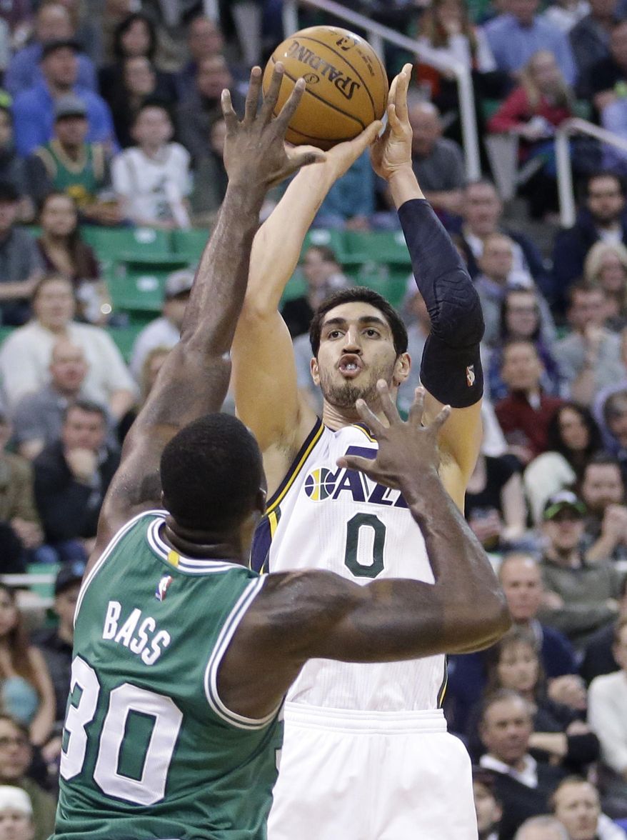 FILE - In this Jan. 26, 2015, file photo, Utah Jazz center Enes Kanter (0) shoots as Boston Celtics forward Brandon Bass (30) defends during an NBA basketball game, in Salt Lake City. A person familiar with the situation says the Jazz have traded Kanter to the Oklahoma City Thunder for fellow center Kendrick Perkins. The person spoke Thursday, Feb. 19, 2015, on condition of anonymity because the teams had not announced the move. There likely will be more players and draft picks involved when the trade is finalized. (AP Photo/Rick Bowmer, File)