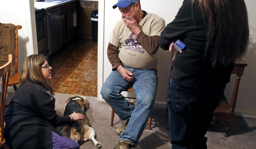 ADVANCE FOR SATURDAY, FEB. 21, 2015 - In this photo taken Jan. 29, 2015, Kenny Pekarovich, center, talks with veterinarian Melanie Cohen, left, during an in-home pet hospice consultation for his 13-year-old beagle, Beady-B. (AP Photo/The Daily Press, Jonathon Gruenke)