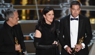 Dirk Wilutzky, from left, Laura Poitras and Glenn Greenwald accept the award for best documentary feature for “Citizenfour” at the Oscars on Sunday, Feb. 22, 2015, at the Dolby Theatre in Los Angeles. (Photo by John Shearer/Invision/AP)
