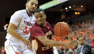 Florida State guard Devon Bookert (1) drives past Virginia guard London Perrantes (23) during the first half of an NCAA basketball game Sunday Feb. 22, 2015, in Charlottesville, Va. (AP Photo/Andrew Shurtleff)