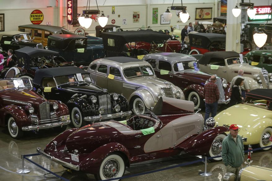 In this photo taken on Tuesday, Nov. 25, 2014, visitors look over the private collection of automobiles during the once-a-week opening to the public at Stahls Automotive Foundation in Chesterfield Township, in Mich. (AP Photo/Detroit Free Press, Ryan Garza) DETROIT NEWS OUT; TV OUT; MAGS OUT; NO SALES; MANDATORY CREDIT DETROIT FREE PRESS