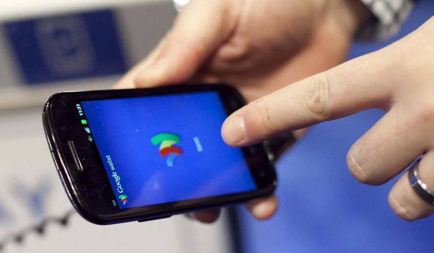 In this Jan. 17, 2012 photo, a person tries a smartphone loaded with Google Wallet at the National Retail Federation in New York. Google is teaming up with three major U.S. wireless carriers in an effort to prod more people into using its mobile wallet and undercut the rapid success of Apple&#39;s rival payment service. (AP Photo/Mark Lennihan, File)