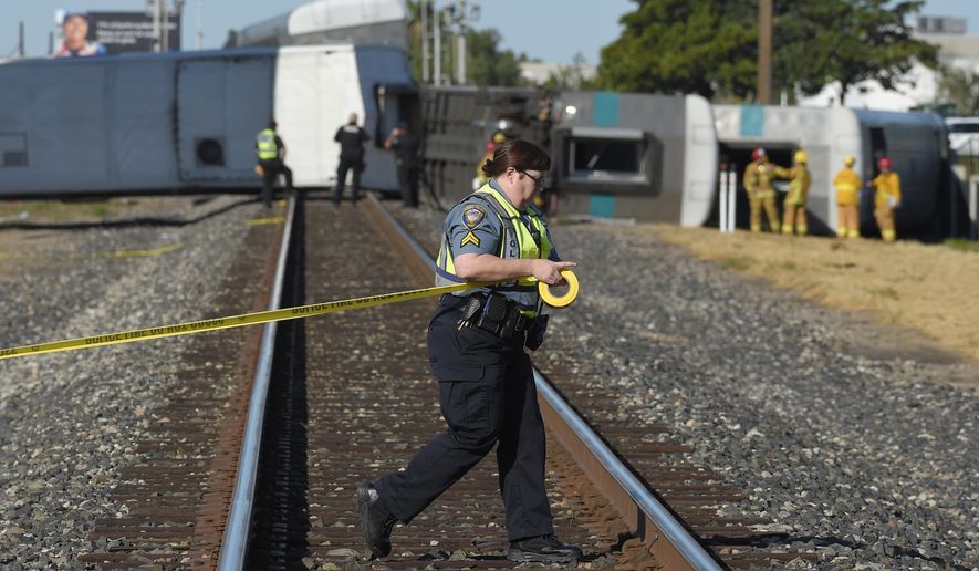 In this file photo, a police officer stretches caution tape across railroad tracks near cars from a Metrolink passenger train that derailed Tuesday, Feb. 24, 2015, in Oxnard, Calif. The Orange County Register reported on April 21, 2018, that a 71-year-old was fatally struck by a Metrolink train nearby a campground where he and his wife were vacationing. (AP Photo/Mark J. Terrill) **FILE**