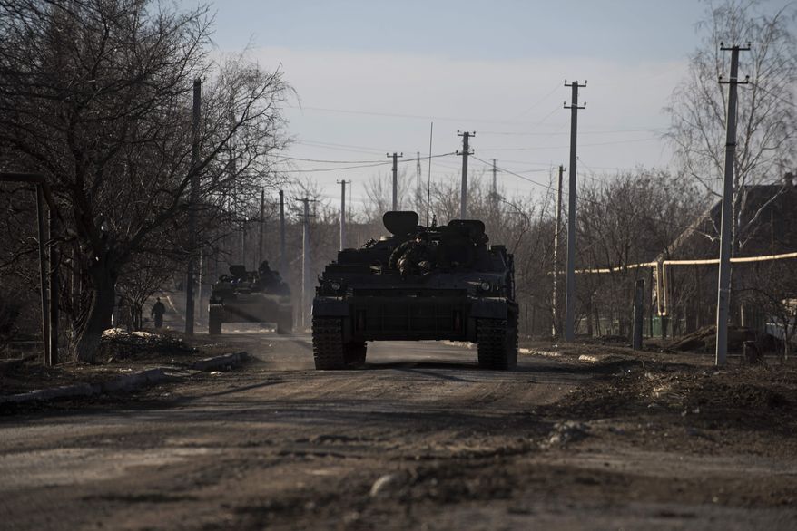 Ukrainian armored vehicles drive near the village of Luhanske, eastern Ukraine, Tuesday, Feb. 24, 2015. Ukrainian officials said they haven’t yet started pulling heavy weapons back from a frontline in eastern Ukraine because of continued rebel violations of a cease-fire deal. (AP Photo/Evgeniy Maloletka)