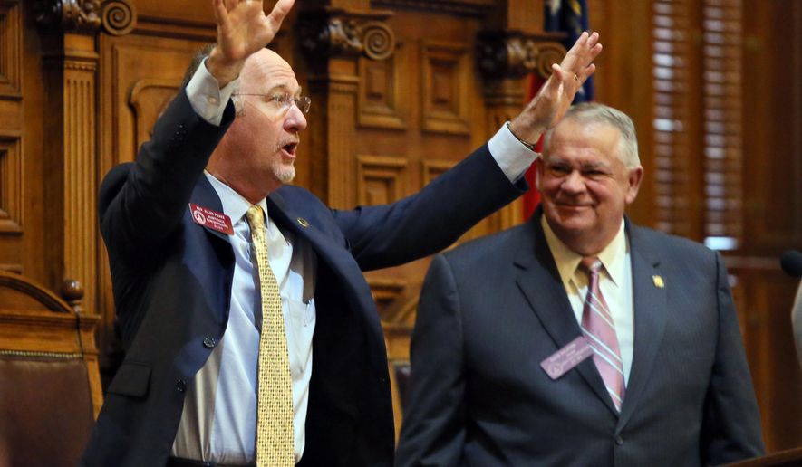 State Rep. Allen Peake, left,, R-Macon, standing with House Speaker David Ralston, acknowledges a standing ovation after the House overwhelmingly passed House Bill 1, Wednesday, Feb. 25, 2015, in Atlanta, to legalize cannabis oil for the treatment of nine major health problems, including sickle cell disease. The bill passed 158-2 and now goes to the state Senate, where considerable opposition is all but certain. Gov. Nathan Deal, who must sign the measure for it to become law, has said he supports the use of cannabis oil for treatment of seizure disorders. (AP Photo/Atlanta Journal-Constitution, Bob Andres) MARIETTA DAILY OUT; GWINNETT DAILY POST OUT; LOCAL TELEVISION OUT; WXIA-TV OUT; WGCL-TV OUT