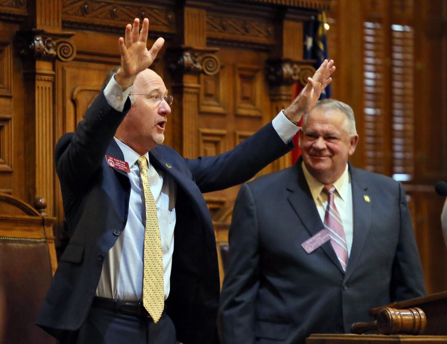 State Rep. Allen Peake, left,, R-Macon, standing with House Speaker David Ralston, acknowledges a standing ovation after the House overwhelmingly passed House Bill 1, Wednesday, Feb. 25, 2015, in Atlanta, to legalize cannabis oil for the treatment of nine major health problems, including sickle cell disease. The bill passed 158-2 and now goes to the state Senate, where considerable opposition is all but certain. Gov. Nathan Deal, who must sign the measure for it to become law, has said he supports the use of cannabis oil for treatment of seizure disorders. (AP Photo/Atlanta Journal-Constitution, Bob Andres) MARIETTA DAILY OUT; GWINNETT DAILY POST OUT; LOCAL TELEVISION OUT; WXIA-TV OUT; WGCL-TV OUT