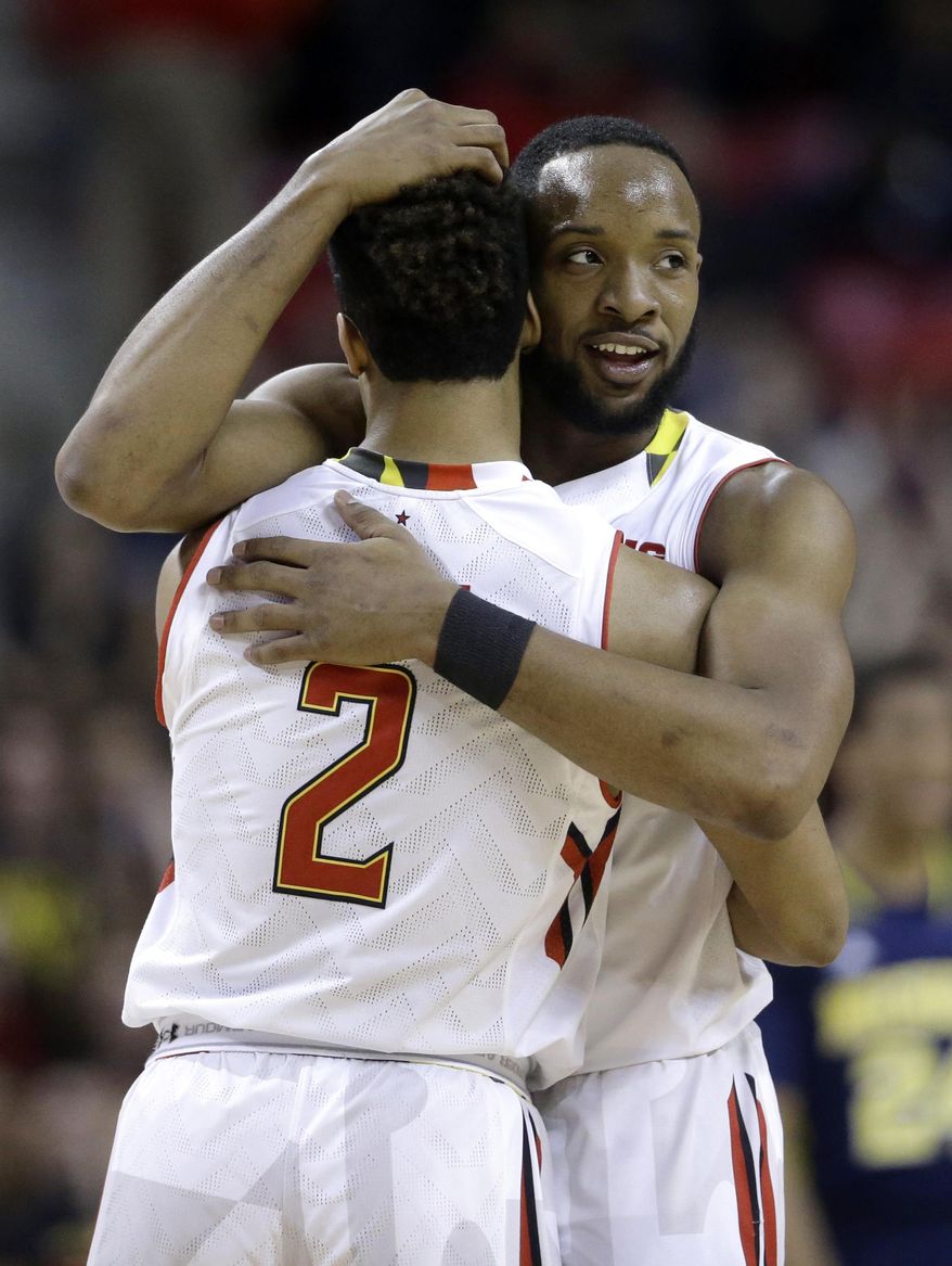Maryland guard/forward Dez Wells, right, hugs teammate Melo Trimble in the final moments of an NCAA college basketball game against Michigan, Saturday, Feb. 28, 2015, in College Park, Md. Wells and Trimble contributed a combined 32 points in Maryland's 66-56 win. (AP Photo/Patrick Semansky)